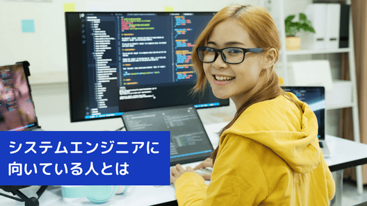 左下に”システムエンジニアの年齢・学歴別平均賃金”と記載。金髪の女性がモニターが置いてあるデスクに座りこちらを振り返る画像
